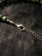 Close-up of metallic lobster claw clasp on Tibetan gemstone necklace