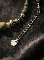 Detail of extension chain with round metal logo tag on agate necklace