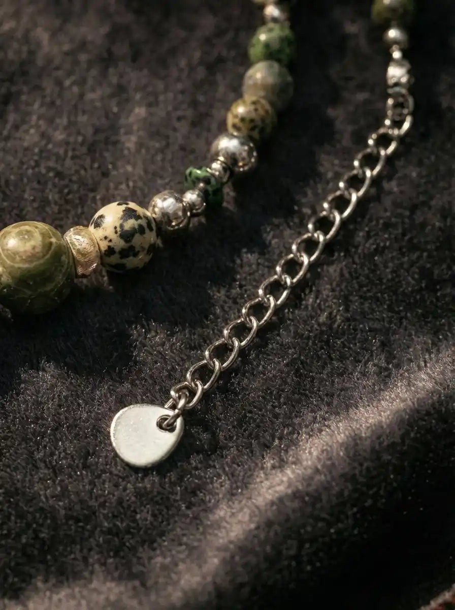 Detail of extension chain with round metal logo tag on agate necklace
