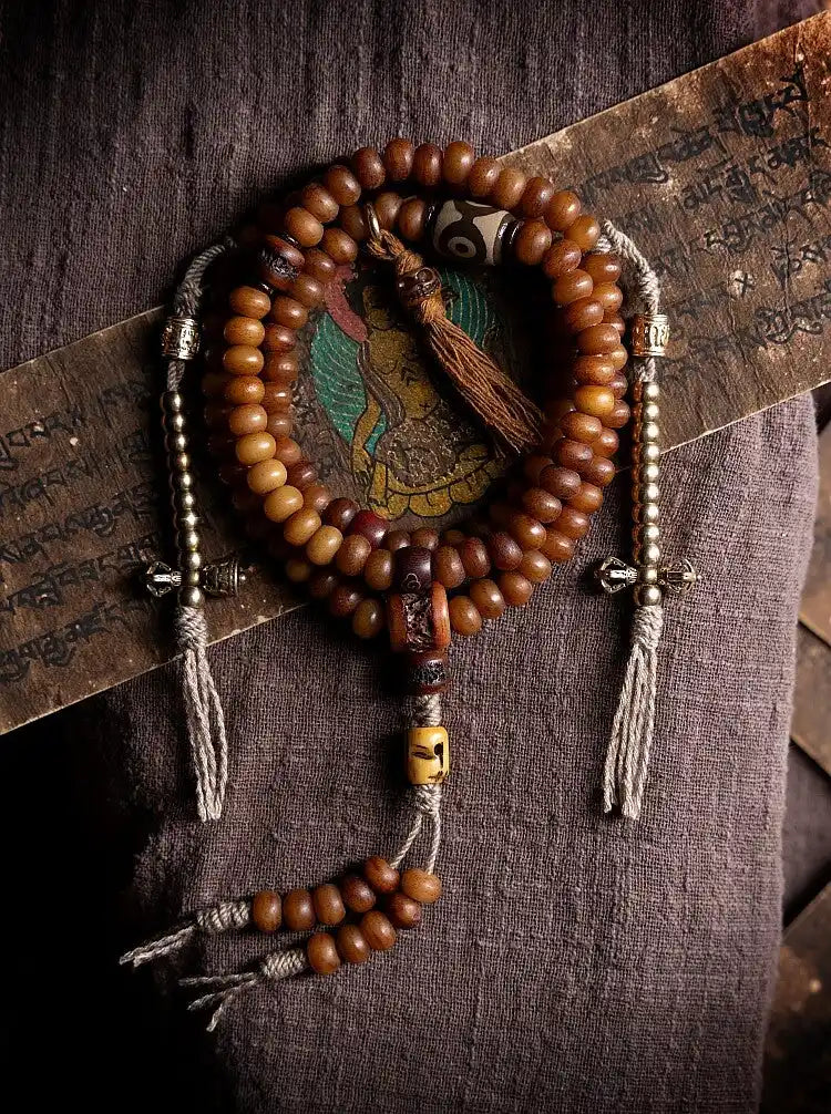 Tibetan yak bone mala showing side brass Vajra Dorje counters with metallic tassels