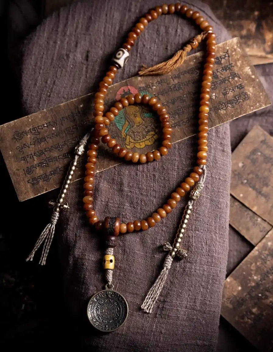 Overview of coiled 108 yak bone mala featuring the Nine Palace Bagua medallion pendant